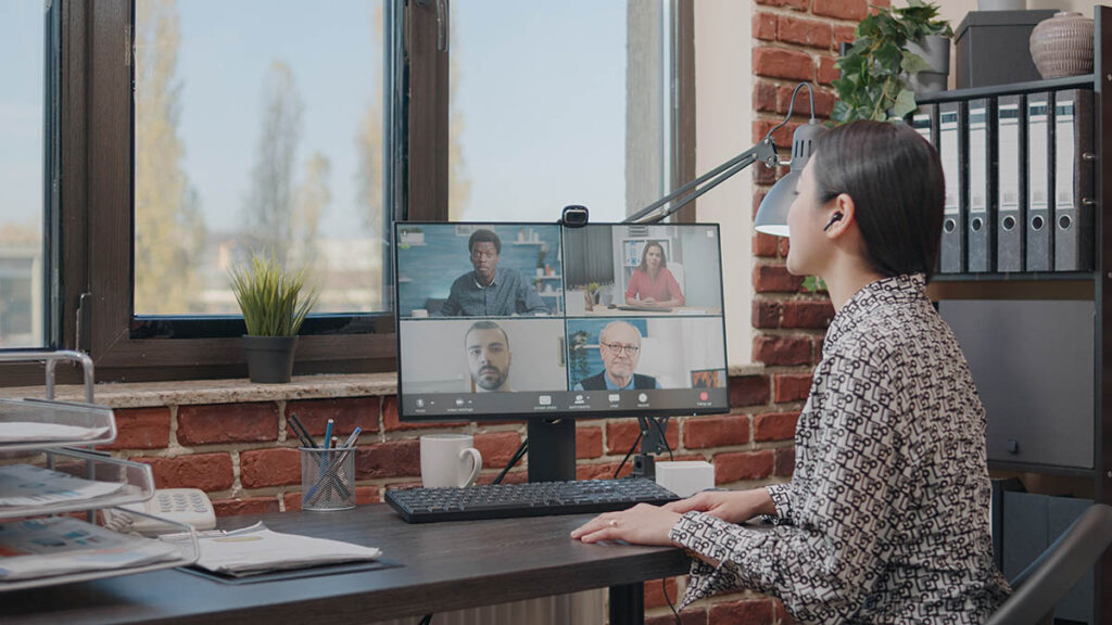 Projektledare deltar i ett Microsoft Teams-videomöte med fyra kollegor på skärmen – illustrerar hur Copilot i Teams-samtal kan transkribera och sammanfatta konversationer i realtid