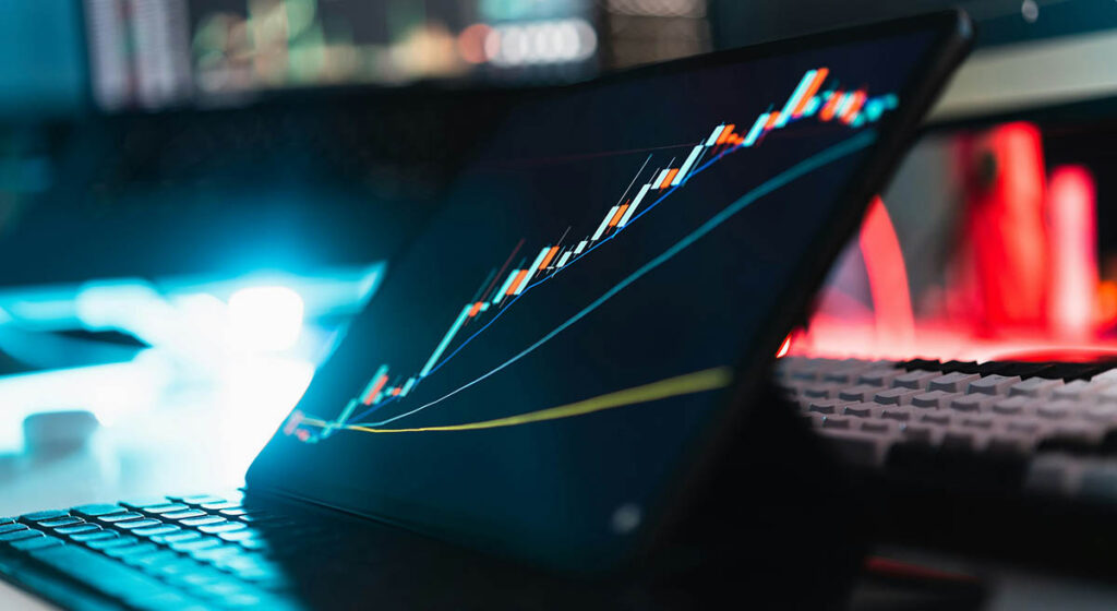Laptop med finansiell graf som visar stigande kurser – illustrerar VD:ars ökade förtroende för AI-investeringarnas avkastning enligt KPMG och BCG 2025